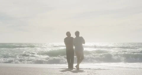 Happy hispanic senior couple dancing on beach at sunset Stock Footage 339589421