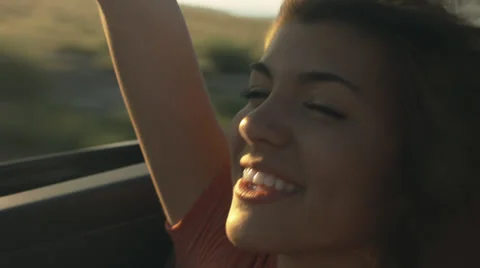 Happy Hispanic Teen Girl Rides In The Back Of Convertible, Raises Arm in The Air Stock Footage
