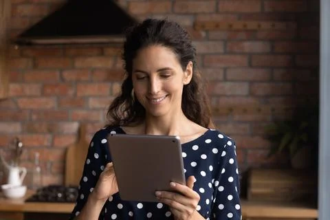 Happy Hispanic woman using computer tablet at home Foto stock