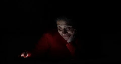 Happy Hispanic Woman Using Electronic Tablet in Dark Environment Lit by Tablet Stock Footage 102929337