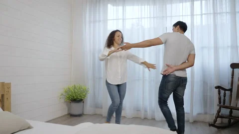 Happy Hispanic young couple having fun dancing in the bedroom Stock Footage 166033552