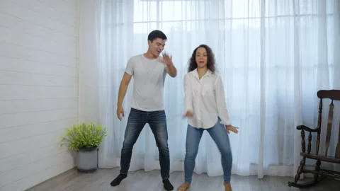 Happy Hispanic young couple having fun dancing in the bedroom Stock Footage 166034309