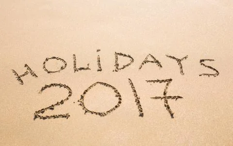 Happy Holidays 2017. Written in sand at the beach. Holiday, Christmas, New Year Stock Photos