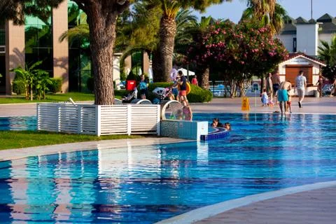 Happy holidays in a beach hotel. People and children having fun in a pool Stock Photos
