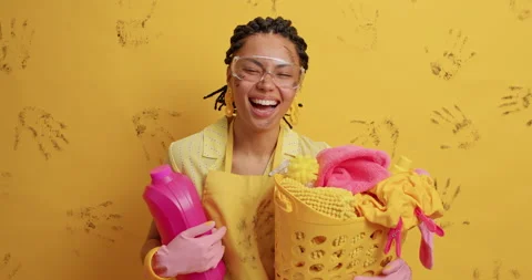 Happy housewife has combed dreadlocks wears transparent glasses protective Stock Footage 152534064