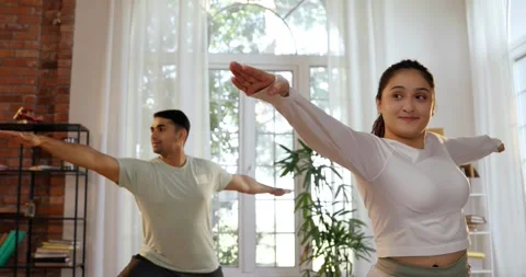 Happy Indian couple practicing yoga ina beautiful home Stock Footage 343410077