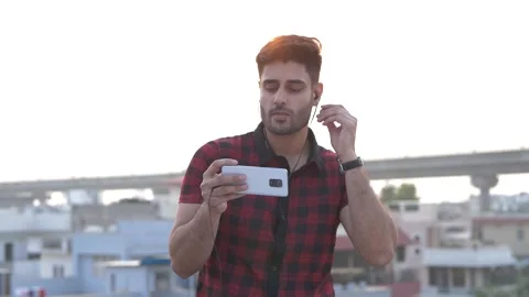 Happy Indian guy dancing and enjoying while listening video songs on cell phone. 動画素材 148824170
