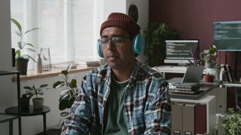 Happy Indian Male Programmer Coding and Enjoying Music in Office Video stock 285710601