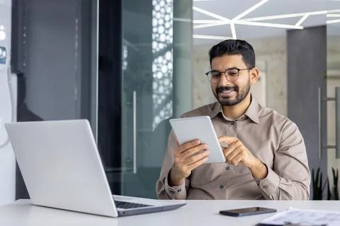 Happy Indian programmer smiling while using tablet in office Stock Photos