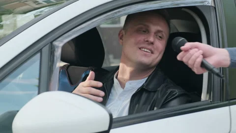 Happy interactive driver answering questions of a journalist Stock Footage 130132724