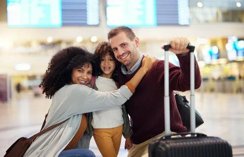 Happy, interracial and portrait of a family at the airport for travel, holiday Stock Photos