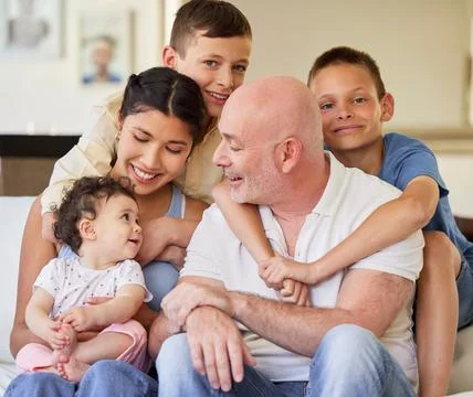 Happy interracial couple bonding with their children at home. Brothers and their Stock Photos
