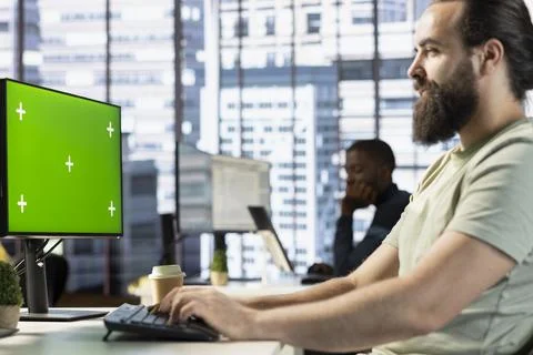 Happy IT specialist programming using mockup computer Foto stock