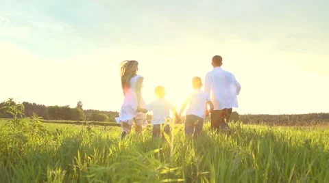 Happy joyful young family with two children running on summer field Stock Footage 59082967