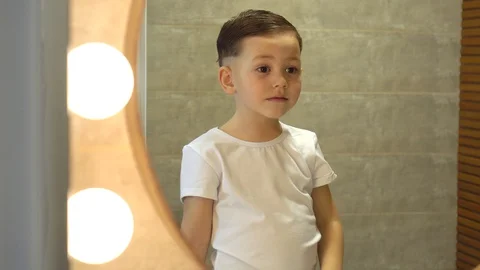 Happy kid boy combing his hair in the morning Stock Footage 128781023