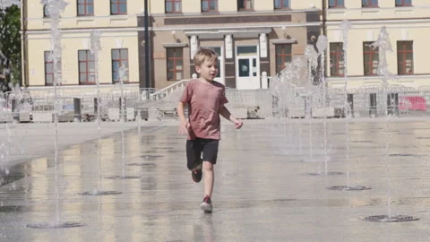 Happy kid boy playing at summer. Child play at the water fountain Stock Footage 164225852