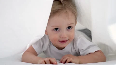 Happy kid crawling under the covers. Happy family. Kid crawling on bed under Video stock 153009322