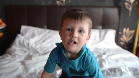 Happy kid jumping on a bed Stock Footage 124167376