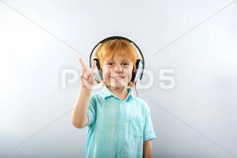 Happy kid listen to music isolated on grey with copy space Stock Photos