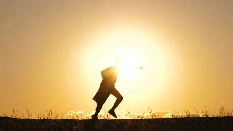 A happy kid in a red cape plays against the background of a beautiful sunset. Th Stock Footage 243517528