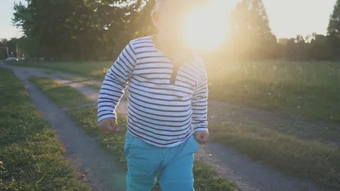 Happy kid runing to the camera on the green grass and smiling. Little boy taking Видео 97543491