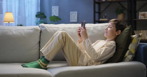 Happy kid using smartphone browsing social media, playing virtual mobile game Stock Footage 263159882