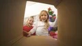 The happy kids open the box near the christmas tree 4k or 4k+ Resolution