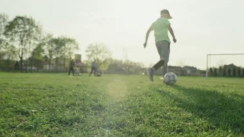 Happy kids playing soccer at sunset. | Stock Video | Pond5