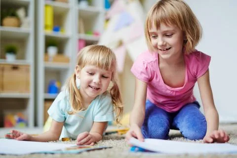 Happy kids playing together in kindergarten Stock Photos