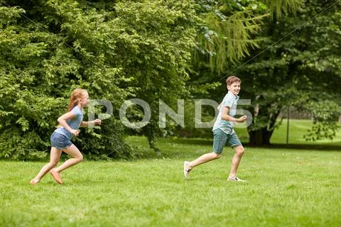 Happy kids running and playing game outdoors Stock Photos