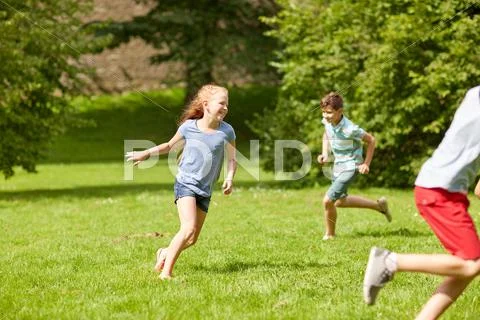 Happy kids running and playing game outdoors Stock Photos