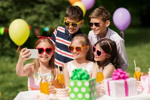 Happy kids taking selfie on birthday party Stock Photos