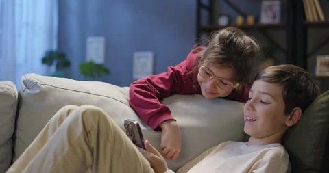 Happy kids using smartphone browsing social media, watching funny video Stock Footage 264805306