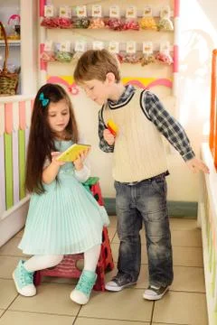 Happy kids using tablet computer in candy shop Stock-Fotos