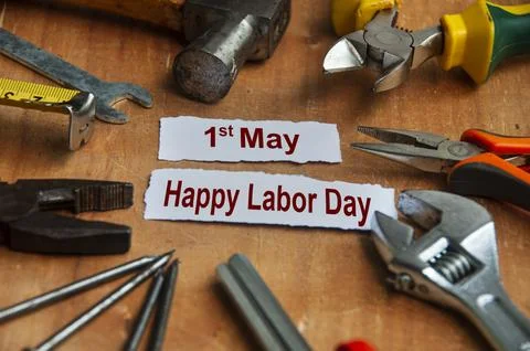 Happy labor day text on torn papers with working tools background. Labor da.. Stock Photos