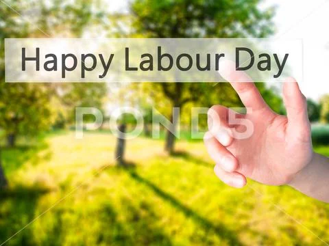 Happy Labour Day - Hand pressing a button on blurred background Stock Photos
