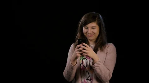 A Happy Lady Using Phone Against Black Background Stock Footage 86590405