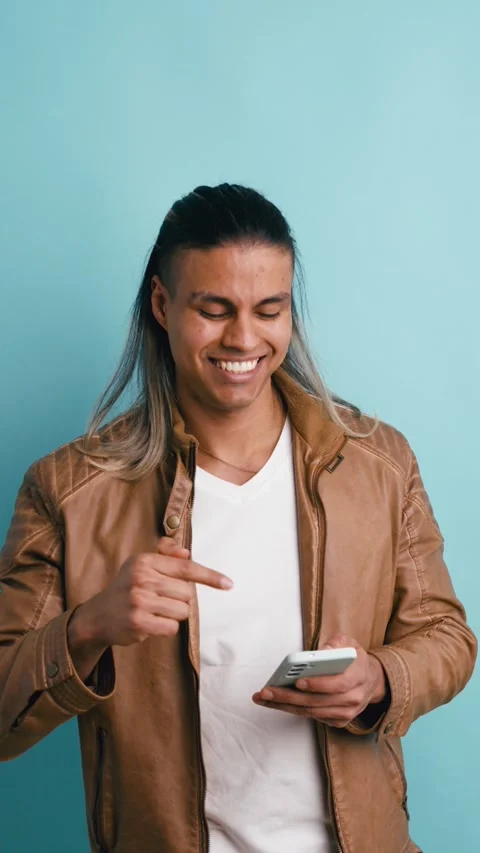 Happy latino man using a smartphone with great idea. Vertical Stock Footage 339325989