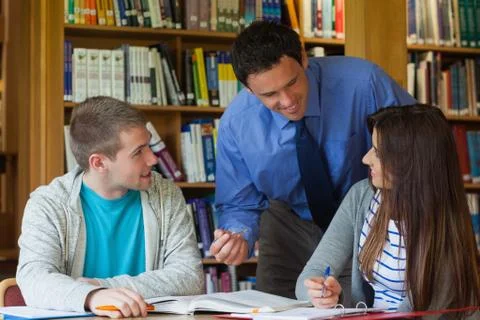 Happy lecturer explaining something to students Fotos Stock