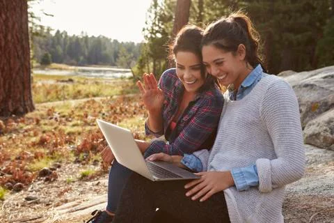 Happy lesbian couple using computer in the countryside 写真素材