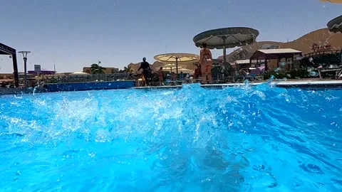 Happy little boy creates splashes in the pool, enjoying the cool water on a Stock Footage 236278651