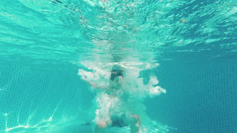 Happy little boy diving in pool blue clear water, fun for children. Summer swim, Stock Footage 346494356