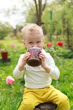 Happy little boy eats Easter Cake, in spring garden, outside. Cute happy litt Stock Photos