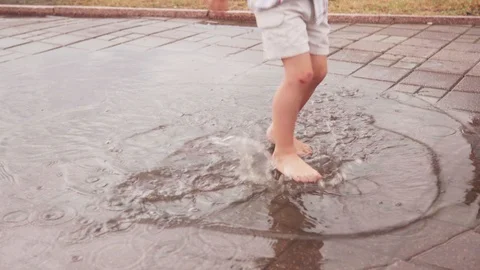 Happy little boy playing in puddle after rain Stock Footage 110892480