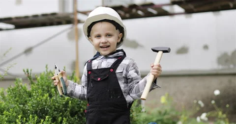 Happy little boy playing with tools at a construction site and smiling. Stock Footage 143559060