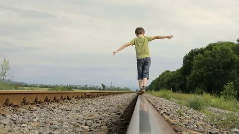 Happy little boy walking on the railway at the day time. Stock Footage