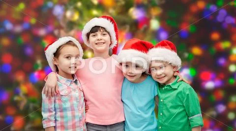 Happy little children in santa hats hugging Stock Photos