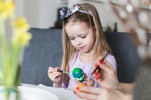 A happy little girl coloring easter eggs. Cozy home atmosphere. Easter Stock Photos