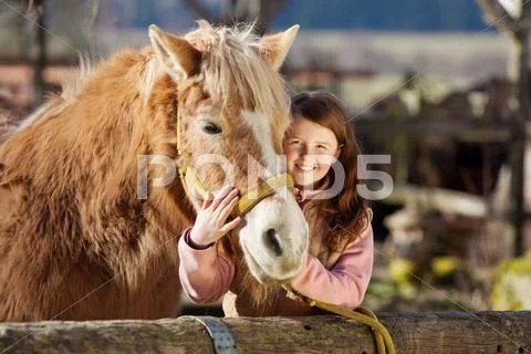 Happy little girl cuddling her horse Stock-Fotos