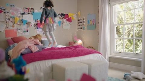 Happy little girl dancing on bed having fun child in playful mood enjoying Stock Footage 111729303